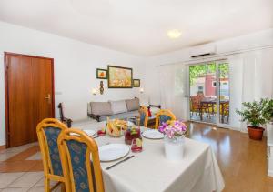a living room with a table and chairs and a couch at Apartments and Rooms Anita in Vrboska