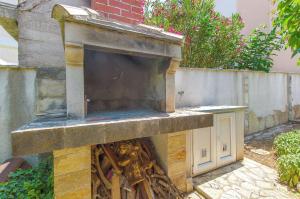 a outdoor pizza oven with a stone wall at Apartment Renata in Sutivan