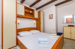 a bedroom with a bed with two towels on it at Apartments Vojka in Milna
