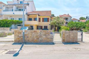 a house with a stone fence in front of it at Apartment Renata in Sutivan