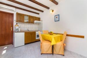 a kitchen with a table with a yellow table cloth on it at Apartments Vojka in Milna