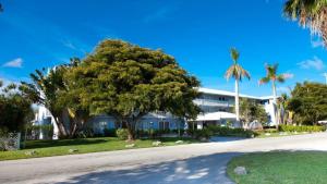 ein großes weißes Gebäude mit Palmen und einer Straße in der Unterkunft Flamingo Bay Hotel & Marina in Freeport