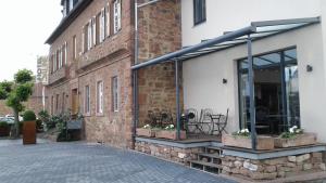 un edificio de ladrillo con ventanas y plantas. en Hotel Saline 3-Sterne Superior en Büdingen