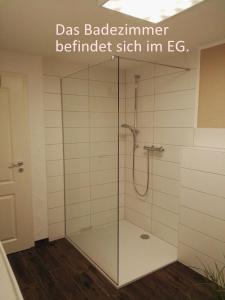 een douche met een glazen deur in de badkamer bij Maifeld-Fewo Sonnenschein in Kerben