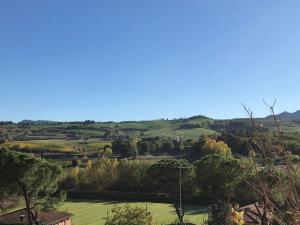 a view of a green field with trees and hills at Hotel Serena in Riolo Terme
