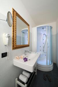 a bathroom with a sink and a shower and a mirror at Nice Hotel Bibione in Bibione