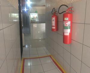 two fire hydrants are on the wall of a bathroom at Hotel Fortaleza III Manaus in Manaus