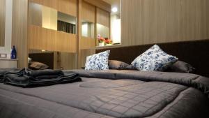 a bed with a blue blanket on top of it at Dusit Grand Condo View Apartment in Jomtien Beach