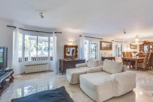 ein Wohnzimmer mit 2 weißen Sofas und einem TV in der Unterkunft Villa Ran de Mar in Port d'Alcúdia