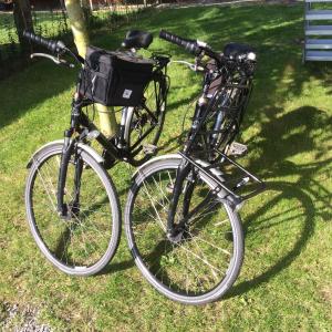 due biciclette parcheggiate l'una accanto all'altra sull'erba di Rap 'n Holiday Home a Sint-Denijs-Westrem