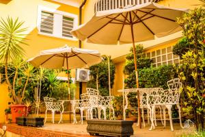 a patio with tables and chairs and umbrellas at Hotel Casa Grande Itapira in Itapira