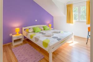 a bedroom with a white bed with a purple wall at Apartment Ante in Milna