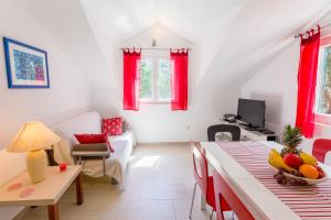 a living room with red curtains and a table with fruit on it at Apartment Ante in Milna