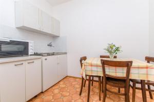 cocina con mesa con sillas y microondas en Apartments Jerka en Sutivan