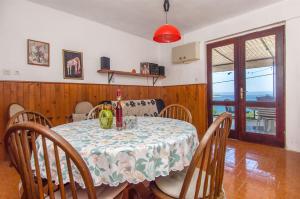 a dining room with a table and chairs with a table and a window at Apartment Ana in Vela Luka