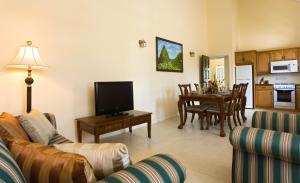 a living room with a couch and a table with a television at Villa Beach Cottages in Castries