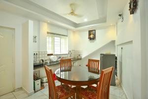 una cucina con tavolo da pranzo e sedie di Aaron's Homestay a Cochin