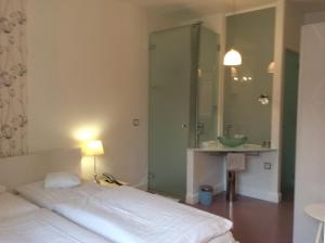 Schlafzimmer mit einem Bett, einem Waschbecken und einem Spiegel in der Unterkunft Hotel Heidelberg Astoria in Heidelberg