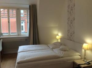 ein Schlafzimmer mit einem weißen Bett und einem Fenster in der Unterkunft Hotel Heidelberg Astoria in Heidelberg