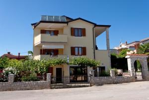 una casa con una recinzione di fronte di Apartments Marija a Novigrad Istria