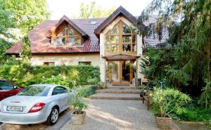 a house with a car parked in front of it at Hotel am Katharinenholz in Potsdam