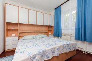 Schlafzimmer mit einem großen Bett und blauen Vorhängen in der Unterkunft Apartment Bozena in Punat