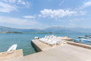 a group of chairs sitting on a dock in the water at Apartment Marko in Tivat