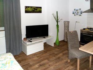 uma sala de estar com uma televisão de ecrã plano num armário branco em Ferienwohnung Anke - Apartment 3b em Heinsberg