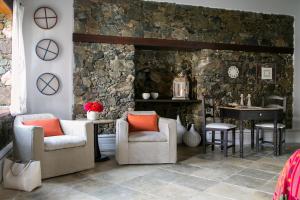 a stone wall with two chairs and a table at Casale Panayiotis in Kalopanayiotis