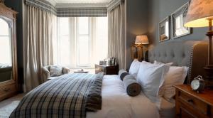 Un dormitorio con una cama grande y una ventana en No.20 Boutique B&B, en Helensburgh