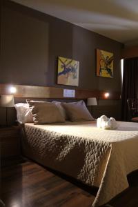 オバールにあるHotel Meia Luaの壁に2枚の写真が飾られたベッドルームの大型ベッド1台