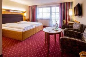 een hotelkamer met een bed en een stoel bij Hotel Amberger Hof in Bad Koetzting