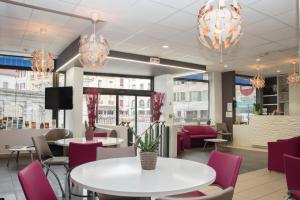 a restaurant with tables and chairs and chandeliers at Hotel Bains Sarrailh in Dax