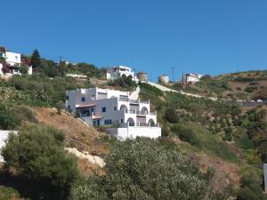 a white house on the side of a hill at Studios RENA in Fourni Ikarias