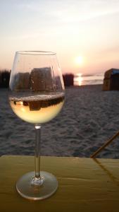 庫克斯港的住宿－Gästehaus am Brockeswald，坐在海滩上的桌子上喝一杯葡萄酒