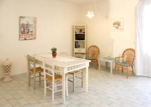a dining room with a white table and chairs at Midiè Savelletri in Savelletri di Fasano