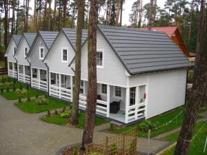 a row of houses in a row with trees at Domki letniskowe in Pobierowo +9 photos