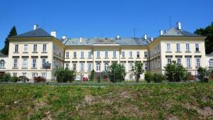 duży biały budynek z białymi oknami i dziedzińcem w obiekcie Domeček u Terčina Údolí w mieście Nové Hrady