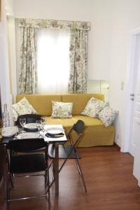 un soggiorno con divano giallo e tavolo di Be My Guest Apartment ad Atene
