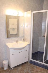 bagno con lavandino bianco e doccia di Be My Guest Apartment ad Atene