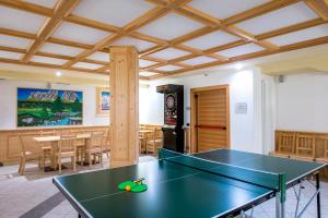 tavolo da ping pong al centro di una stanza di Hotel Villa Rosella Park & Wellness a Canazei