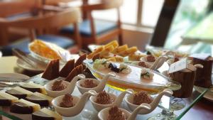 a tray of desserts on a table with a plate of food at Season Paradise in Thulusdhoo
