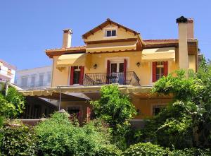 Una casa amarilla con balcón en la parte superior. en Venetula's Mansion en Kastoria