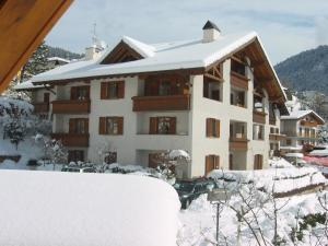 a large building with snow on the roof at Residence Stefenine in Molveno