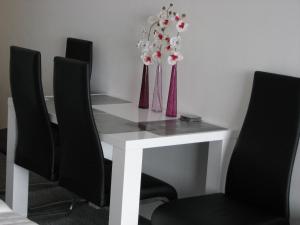 タウプリッツにあるTauplitz - Kulmhofのダイニングルームテーブル(椅子2脚、花の飾られた白いテーブル付)