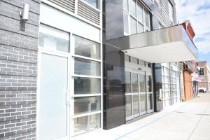 a facade of a building with a large glass door at The Queens Hotel in Queens