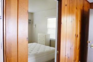Dormitorio pequeño con armario y cama en By the Lake, en Clearlake