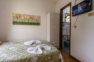a bedroom with a bed with towels on it at Itaporanga Pousada in Santa Maria Madalena