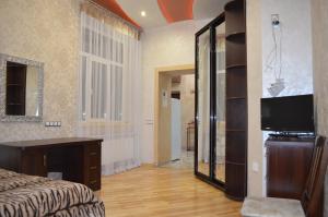 - une chambre avec un lit, une télévision et un miroir dans l'établissement Apartamenty Novyi Svit, à Lviv