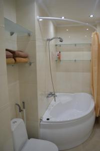 La salle de bains est pourvue d'une baignoire blanche et de toilettes. dans l'établissement Apartamenty Novyi Svit, à Lviv